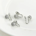 Dettaglio di quattro clip per orecchie argentate con zirconi su vassoio in ceramica - Stile Clip Spirale Zirconia Tondo 4# / Argento