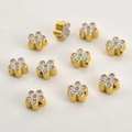 Detailed macro of 18k gold flower beads with blue and purple enamel for DIY jewelry - Gold Purple Blue Flower
