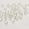 Makro-Detail von silberfarbenen Ovalperlen mit Doppellöchern für DIY-Schmuck und Bastelarbeiten - Dickes Silber Doppeloch Ring (5mm)