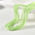 Makroaufnahme von 2mm hellgrünen Katzenaugenperlen für DIY handgemachten Schmuck - Fluoreszierendes Grün Katzenaugen-Stil