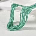 Nahaufnahme von 2mm grünen Katzenaugen-Perlen für DIY-Schmuck und Halsketten - Hellblaugüner Katzenaugen-Stil