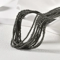 Detail von 2mm dunkelgrauen Katzenaugen-Perlen auf Keramikdisplay für DIY-Schmuck - Dark Gray Cat Eye Style