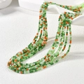 Macro shot of 2mm multifaceted colorful glass beads hanging on a ceramic bowl - Orange Green and White Mix (MH-4)
