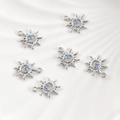 Macro view of six sun-shaped 14k gold plated charms with blue zircon center stones - White Gold Sun (14.8*12.3mm)