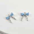 Macro detail of two light blue zircon bow pendants with silver plating for DIY jewelry - Silver Base Light Blue Turquoise Bow