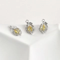 Detailed view of three hollow leaf pendants with yellow pear-cut stones and tiny zircon - White Gold Plated Lemon / Yellow