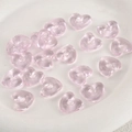 Makro-Detail von transparenten hellrosa herzförmigen Glasperlen für DIY-Schmuckherstellung - Rosa Herz