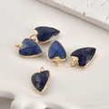 Vue macro de 5 pendentifs cœur en lapis-lazuli bleu avec bordure en métal doré - Cœur pointu en lapis-lazuli