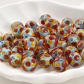 Nahaufnahme von Lampwork-Glasperlen mit bunten Punkten für DIY-Schmuckherstellung - Hellblau