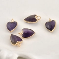 Détail macro de cinq pendentifs cœurs en cristal violet facetté avec bords en métal doré - Cœur Améthyste