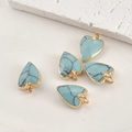 Vue macro de 5 pendentifs cœur en turquoise avec bord doré pour la création de bijoux - Cœur Turquoise Bleue