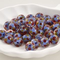 Makroaufnahme von hellblauen Glasperlen mit roten und gelben Punkten für DIY-Schmuck - Blau