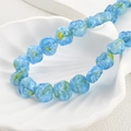 Macro shot of light blue glass rose beads with yellow core details for DIY jewelry - Aqua