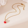 Close-up of golden necklace with a red enamel strawberry pendant on a minimal background - Strawberry Necklace Style G (25WN034)