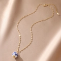 Detail of 18K gold-plated necklace with blue and white porcelain bead on silk background - Round Style