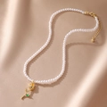 Detail of multi-layer pearl necklace with a gold rose pendant and green leaf accents - Yellow Rose