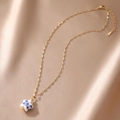 Detail view of gold stainless steel necklace with blue and white porcelain star pendant - Star Style