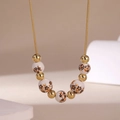 Close-up of a gold snake chain necklace with floral ceramic beads and 18K gold-plated spacers - Orange