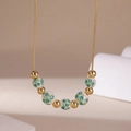 Detail of 18K gold chain necklace with floral ceramic beads and shiny golden spheres - Green