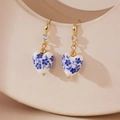 Detailed close-up of heart-shaped blue and white porcelain earrings with gold hooks - Heart Style (Model B)