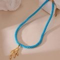 Detailansicht der blauen Seidenkordelkette mit goldener Korallenzweig-Anhänger - Baumzweig