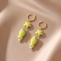 Dettaglio di orecchini in ceramica a forma di stella marina e pesce con perle - Verde