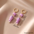 Dettaglio degli orecchini pendenti in ceramica con stella marina viola e pesce lilla - Viola