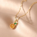 Golden fruit necklace featuring a realistic orange slice pendant on soft silk background - Lemon