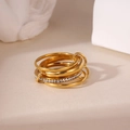 Vista macro di anelli d'oro a strati con pavé di zirconi e maglie intrecciate - Stile Impilato con Strass Dorato (Modelo E)
