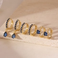 Detailed shot of three gold hoop earrings set with navy blue and clear cubic zirconia stones - 3 Pairs Set / Gold Blue