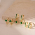 Detailed macro view of gold-plated hoop earrings with emerald green zircon inlays - 3 Pairs Set / Gold Green