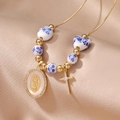 Blue ceramic beaded necklace with gold Virgin Mary pendant and cross on satin - Gold