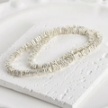 Macro shot of 4mm silver lava stone square spacer beads on a white stone base - Silver