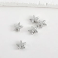 Dettaglio di cinque ciondoli a stella marina in argento con perline su sfondo bianco - Stella marina / Oro bianco