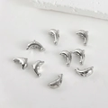 Close-up of dolphin-shaped silver plated metal beads for DIY jewelry making and crafts - Dolphin / White Gold