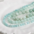 Macro shot of 8mm natural Persian jade round beads with blue and green mineral textures - Amazonite Blue 8mm (Approx. 46 Beads)