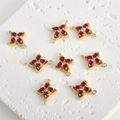 Detailed view of gold-plated clover jewelry connectors with red zircon stones for DIY - Red