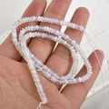 Vue macro de perles en cristal blanc translucide avec un éclat irisé subtil - Pierre d'Opale - Petit