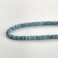 Macro detail of light blue heishi beads with black marble veins on a clean gray background - 28# Abacus Bead Style / 2x6mm (160 Pieces/Pack) / Blue Turquoise