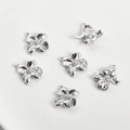 Macro shot of silver five-petal flower charms with zircon inlay for jewelry making - White Gold Four-Petal Flower
