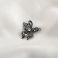 Macro detail of dark butterfly pendant with crystal inlay on white satin background - Gunmetal