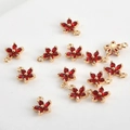 Détail macro de pendentifs fleurs à cinq pétales dorés avec zircon rouge pour bijoux DIY - Fleur rouge à cinp pétales