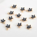 Vue détaillée de douze pendentifs fleurs à cinq pétales plaqués or avec zircons bleu foncé - Fleur Bleu Foncé