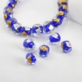 Detailed macro of handmade dark blue glass bead with internal gold and silver foil flakes - Royal Blue Square #7