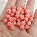 Macro detail of coral pink spiral pumpkin beads held in hand for jewelry DIY - Style 1 Twisted Spacer (Approx 7.8x8mm Hole 1.5mm)