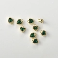 Macro view of 14k gold-plated heart pendants with faceted green zircon and detailed metal edges - Green Zirconia
