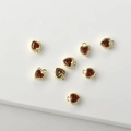 Macro view of 14k gold-plated heart charms with red cubic zirconia for DIY jewelry making - Red Zirconia