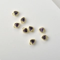 Detailed macro of seven purple heart-shaped zircon pendants with 14k gold-plated frames - Purple Zirconia