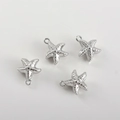 Detailed view of four silver starfish pendants with textured finish and DIY hanging loops - White K Starfish (10x9mm)