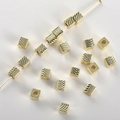 Macro-opname van 14k vergulde vierkante kralen met gefacetteerde textuur en gat - 14k Goud Oogpatroon Vierkant (4mm Gat 1,8mm)